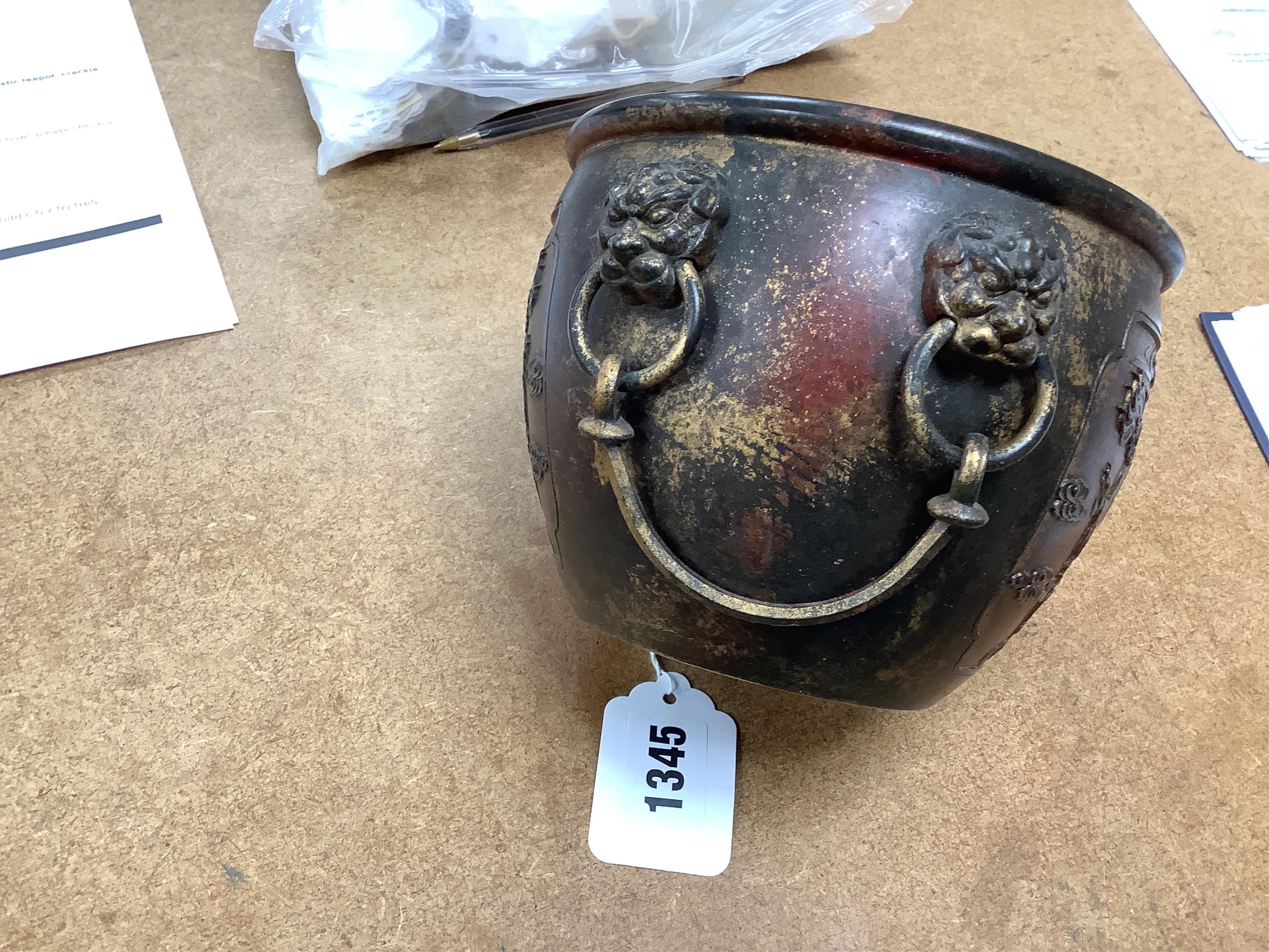 A Chinese partially gilt bronze censer, decorated in relief with twin handles, 16cm in diameter